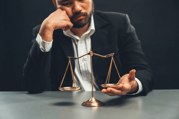 istock Lawyer or judge in formal black suit hold unbalanced scale . equility 1483001815