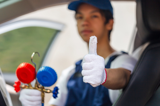 Technician showing thumbs up and holding monitor tool to check and fixed car air conditioner system, Repairman check car air conditioning system, Air Conditioning Repair