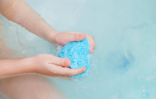 istock A child in the bath is holding a blue bath bomb with coconut extract. Copy space for text 1483004731
