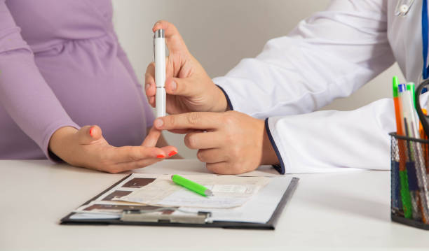 medición de la viscosidad y el azúcar en la sangre en una niña embarazada. niveles altos y bajos de azúcar en la sangre durante el embarazo, deficiencia de insulina - diabetes human pregnancy women blood sugar test fotografías e imágenes de stock