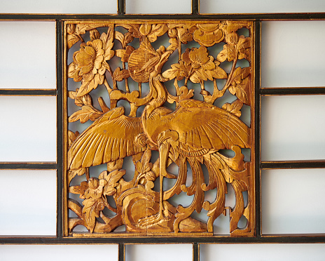 Horizontal close up of small section of ornate French provincial porcelain pattern design inlay on wood furniture table piece