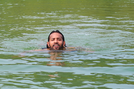 senior man swimming on the blue ocean -health and activity concept