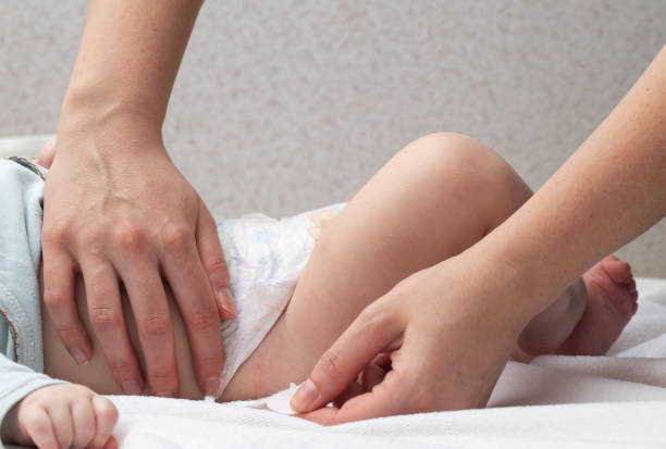 istock The mother fastens the fasteners and changes the baby's diaper, close-up. Copy space for text 1483006160