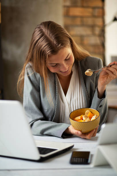 Businesswoman in office having healthy snack. stock photo