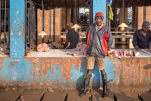 An elderly woman shopping at the fish market.