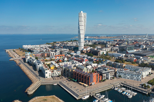 Aerial view of the Västra Hamnen (West Harbor) district in Malmö, with apartment buildings along the water and the Turning Torso building rising high above the surrounding buildings.