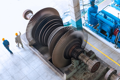 Large powerful steam turbine with shiny silver blades and holes with thread of screw in plant workshop extreme close view