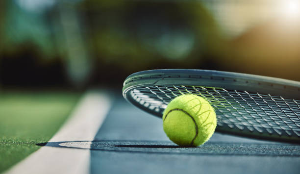 Tennis ball, racket and court ground with mockup space, blurred background or outdoor sunshine. Summer, sports equipment and mock up for training, fitness and exercise at game, contest or competition stock photo