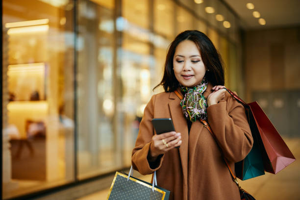 istock Asian woman using app on smart phone while spending her day in shopping. 1483013678