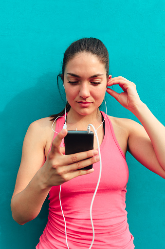 Beautiful young woman listening music on mobile phones after exercise