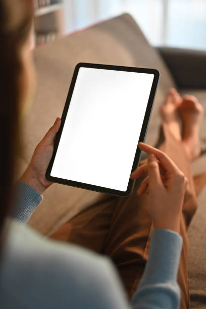 istock Closeup woman holding empty screen of digital tablet on sofa. 1483013878