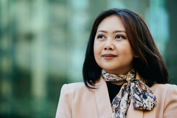 istock Smiling Asian businesswoman outdoors looking away. 1483013885