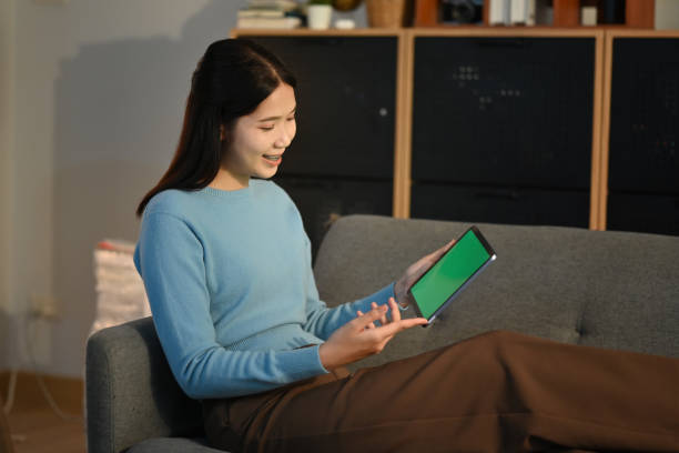 istock Young woman using tablet on sofa at home. 1483014033