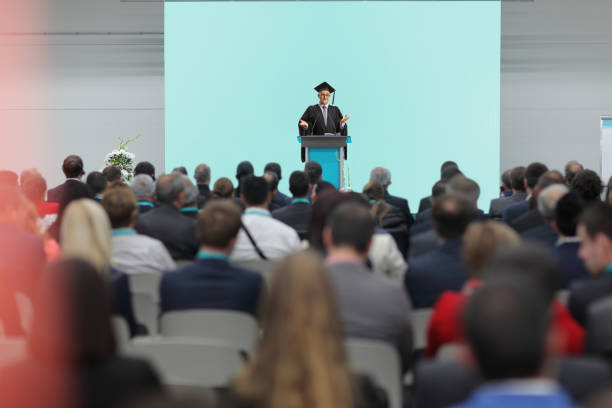 istock Dean giving a speech at a podium in front of people in audience 1483014098