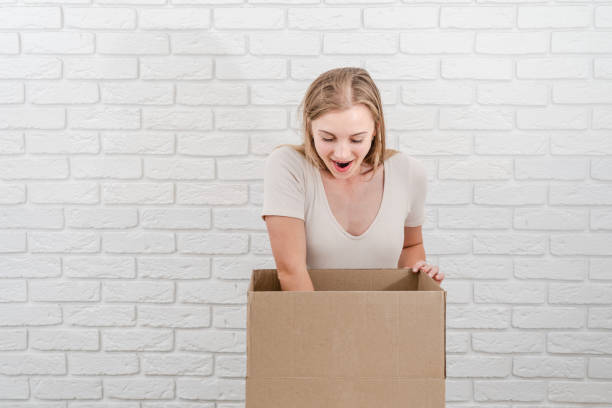 istock Attractive blonde woman with open cardboard box. Delivering a parcel 1483016034