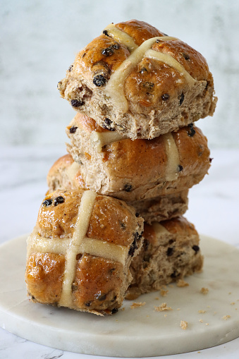 Stock photo showing freshly cooked, homemade Easter hot cross buns, home baking concept.
These traditional spiced sweet buns are made and sold over the Easter period, with the cross symbol on the glazed top being made from a flour and water paste, and symbolic to Christianity.