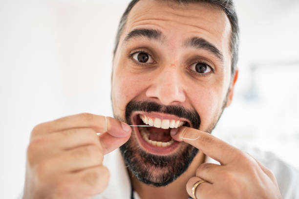 istock Man flossing his teeth in a dentist's office 1483018505