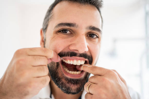istock Man flossing his teeth in a dentist's examination office 1483018513