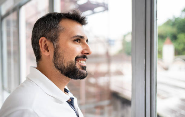 istock Smiling male dentist looking through a window in his office 1483018534