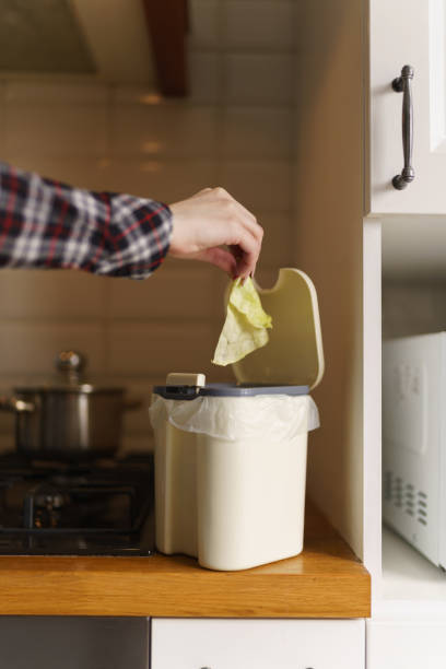 istock Female hand throwing compostable food leftovers in a bokashi container with compost 1483018629