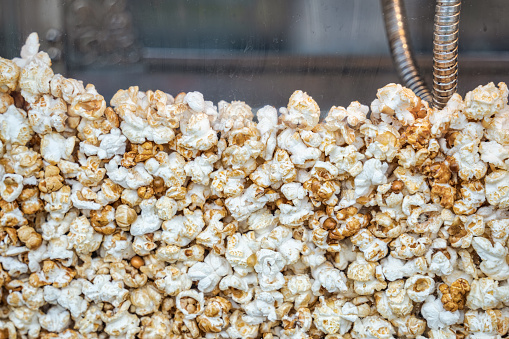 Close up with a fresh salty popcorn. Machine popcorn maker texture background.