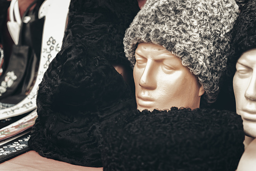 Man Mannequin with a woolen hat or beanie in a window store.
