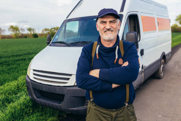 istock Happy confident male driver standing in front on his van and looking at camera. 1483021912