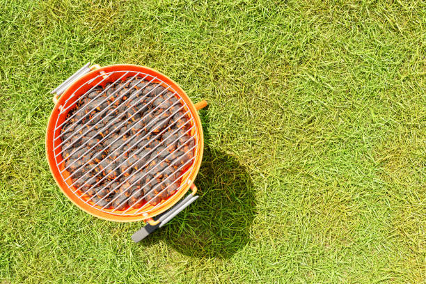 3D rendering of top view of charcoal kettle steel grill BBQ placed on green lawn during sunny summer day