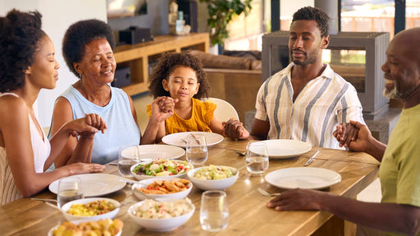 istock Multi-Generation Family Joining Hands And Saying Prayer Before Meal At Home 1483023706