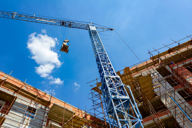 크레인은 구겨진 호일로 가득 찬 카트를 땅, 산업 쓰레기, 건설 현장 작업으로 내리고 있습니다 - crane hoisting derrick crane built structure 뉴스 사진 이미지