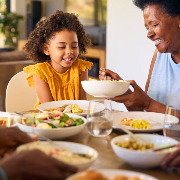 istock Multi-Generation Family Sitting Around Table Serving Food For Meal At Home 1483023789