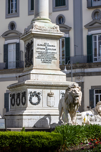 Naples, Italy - June 27, 2021: Stone lion statue at the base of the Monument to the Martyrs on Piazza dei Martiri. The four lions represent the Neapolitan patriots who fell during the anti-Bourbon revolutions
