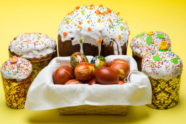 istock Easter Traditions: Blessing Paskha and Colorful Eggs on a Radiant Yellow Background 1483028076