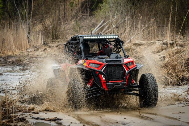 istock ATV/UTV/4x4 driving throw splashing past a muddy large puddle in forest 1483028487
