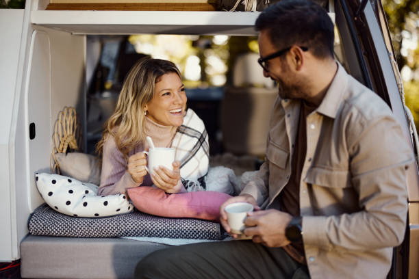 istock Happy couple talking while relaxing in camper trailer. 1483031968