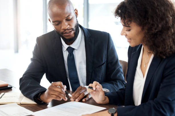 istock Business, black man and advisor consulting with paperwork, review report or portfolio documents. Teamwork, consultant and meeting for executive analysis, planning legal feedback or consultation notes 1483033795