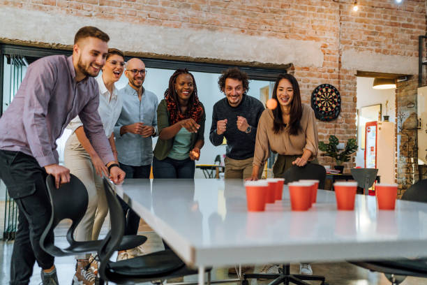 istock Young colleagues playing beer pong in the office 1483034288