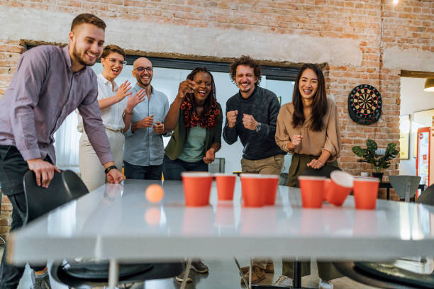 istock Coworkers playing beer pong in the office 1483034319