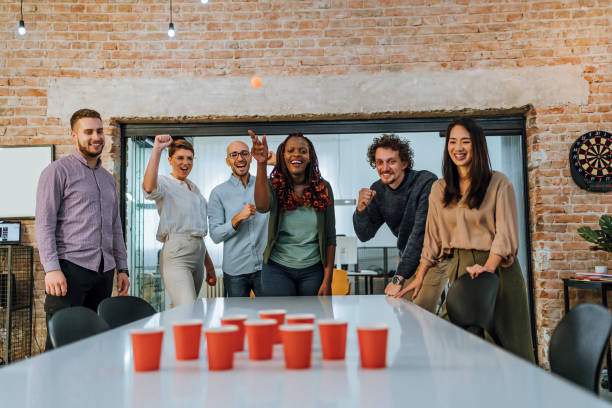 istock Young colleagues playing beer pong in the office 1483034440