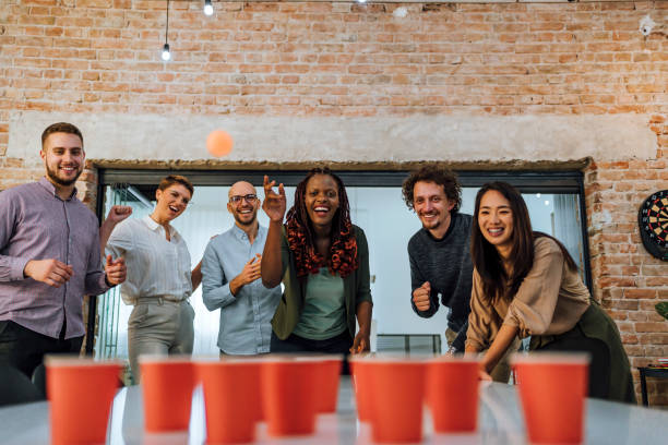 istock Young colleagues playing beer pong in the office 1483034648