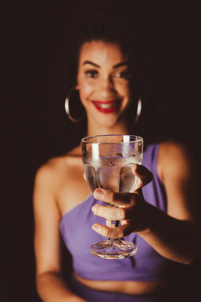 jeune belle femme souriante montrant une tasse en verre. - wall indoors chair floor photos et images de collection