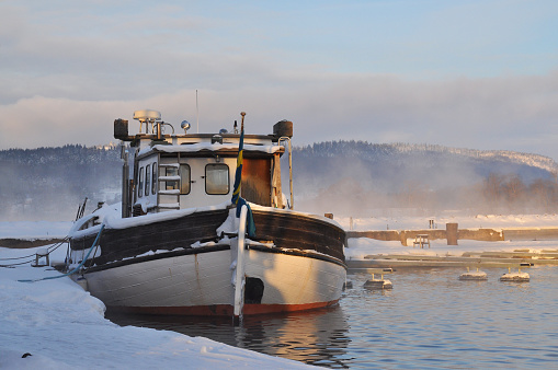 Boat docked in misty wintertime.