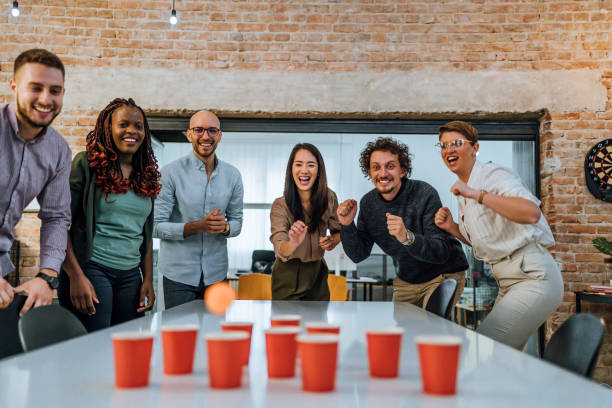 istock Coworkers playing beer pong in the office 1483035363