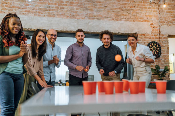 istock Coworkers playing beer pong in the office 1483035470