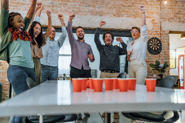 istock Coworkers playing beer pong in the office 1483035565