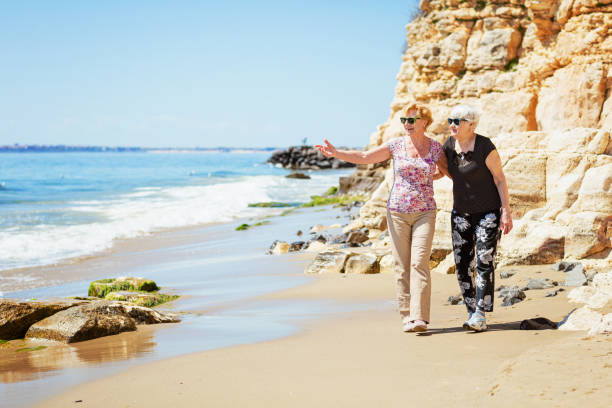 istock Two elderly women are walking along the rocky shore 1483041499