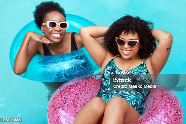 Two Young Black Friends Float In Inflatable Rings In Pool Swimming Having Fun Stock Photo - Download Image Now