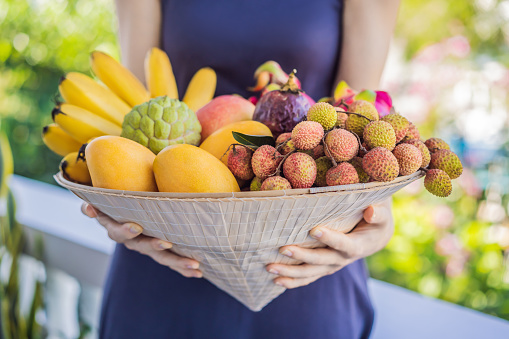 Variety of fruits in a Vietnamese hat. Woman in a Vietnamese hat