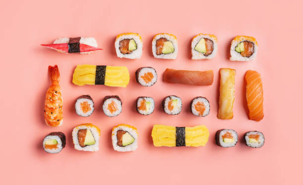 food knolling concept - top down view of various nigiri sushi and sushi rolls on pink background - food sushi seafood maki sushi imagens e fotografias de stock