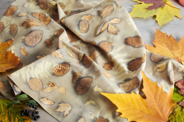 istock Hand-dyed silk scarf surrounded by autumn leaves. Eco-print technique 1483043719